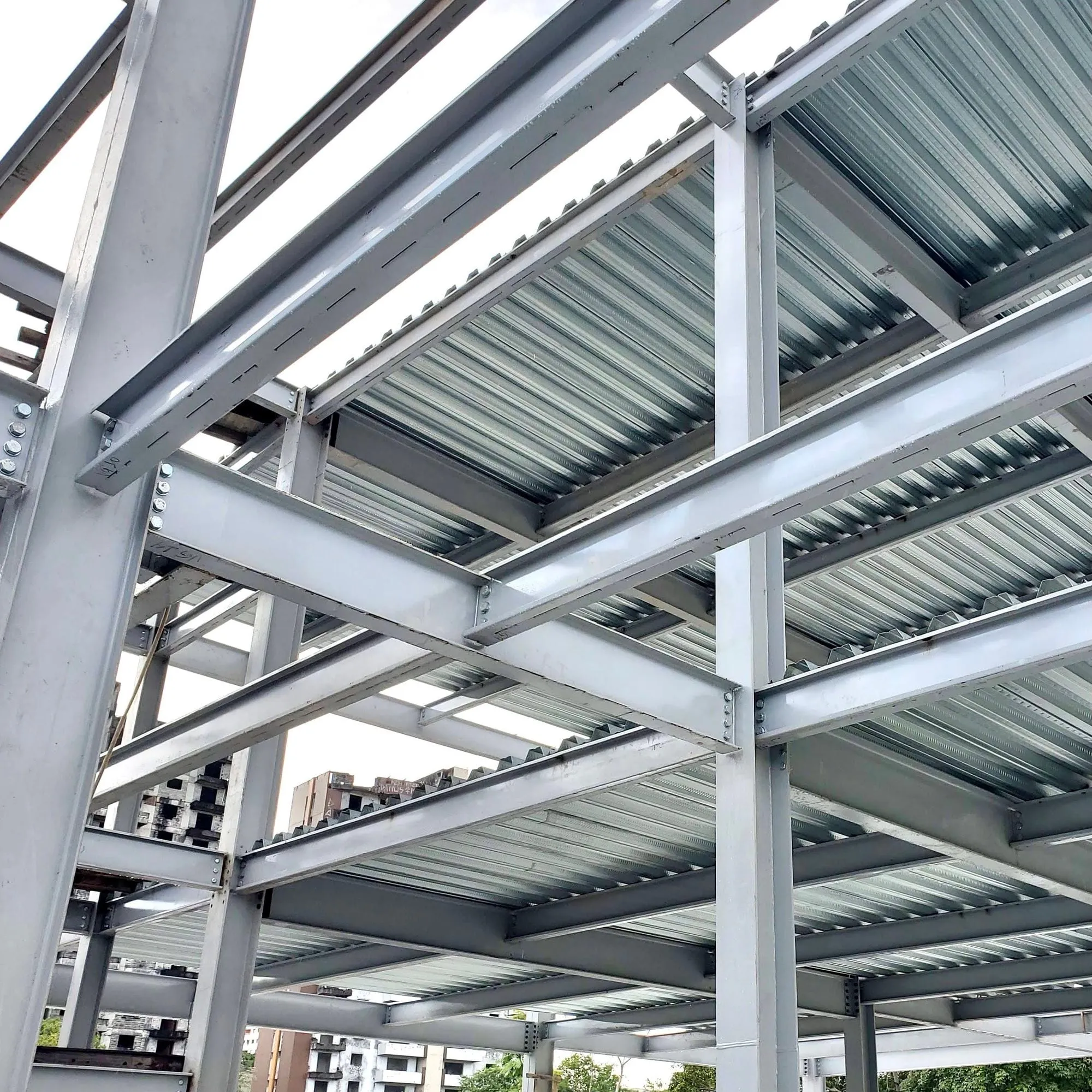 Estrutura metálica de um edifício em construção, vista de baixo, com vigas e laje de aço