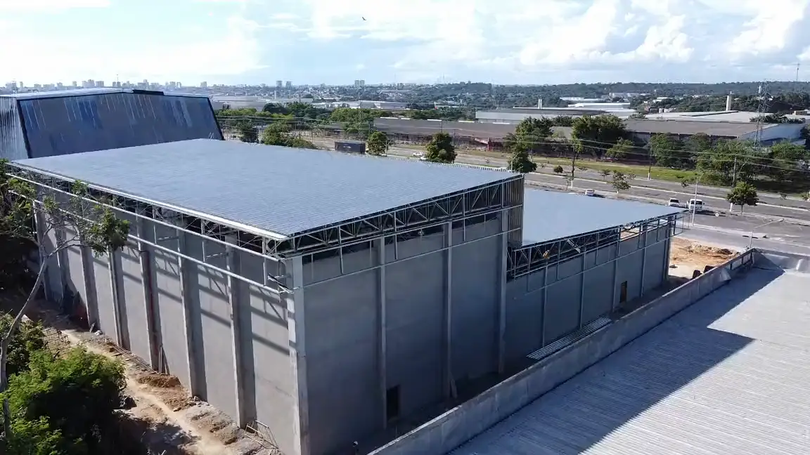 Vista aérea, de drone, do galpão com a estrutura, os fechamentos e a cobertura metálica montados. Registro de obra da Platinum.